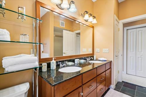 a bathroom with two sinks and a large mirror at Make this beautiful property your family vacation home while in Killington B301 in Killington