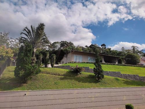 a house on a hill with a palm tree at Casa Central com Vista Exclusiva in Pomerode