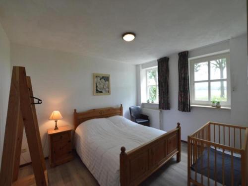 ElsendorpにあるDe open schuurのベッドと椅子と2つの窓がある寝室