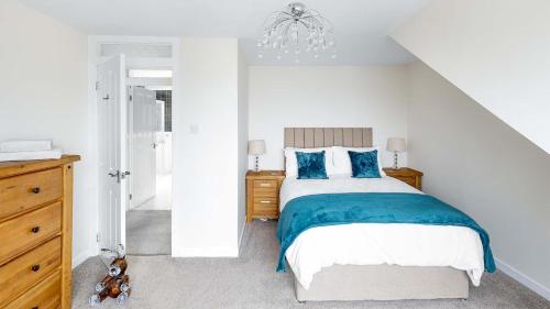 a bedroom with a large bed with blue pillows at Sea The View in Rothesay