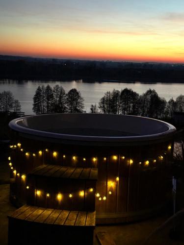 ChrostkowoにあるChojno 31i- dom wypoczynkowy przy jeziorze z jacuzziの埠頭にある照明付きの大きな円形の建物