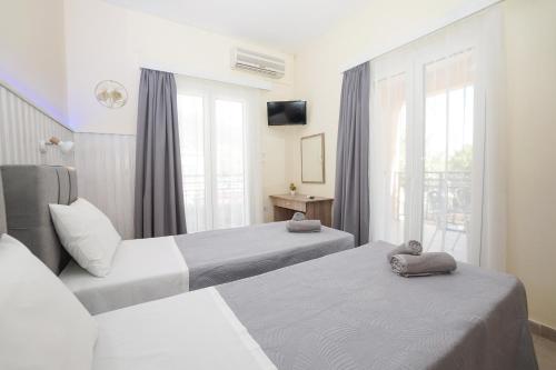 a hotel room with two beds and a window at Ipsos Wave Apartments in Ipsos