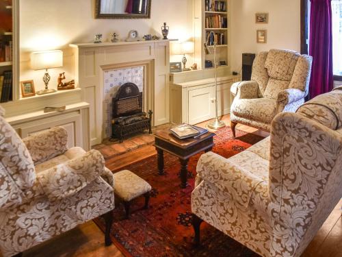 ein Wohnzimmer mit Stühlen und einem Kamin in der Unterkunft The Old Sweet Shop in Kings Lynn
