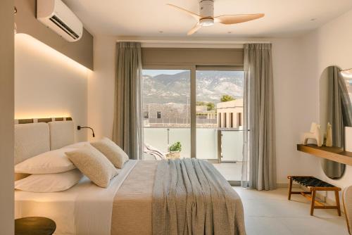 a bedroom with a bed and a large window at Ionian Treasure Suites in EFL