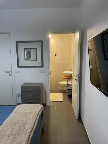 a bedroom with a bed and a bathroom with a sink at Villa Stella Marina in Porto Cesareo