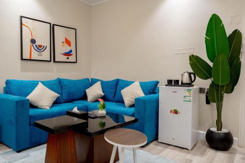 a living room with a blue couch and a refrigerator at استديو رائع في العليا 203 in Riyadh