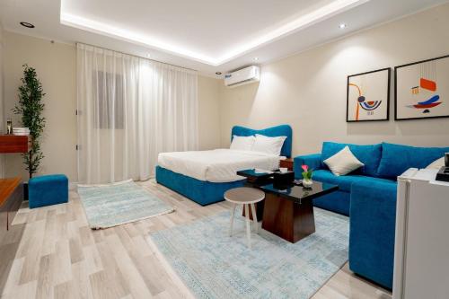 a living room with a blue couch and a bed at استديو رائع في العليا 203 in Riyadh
