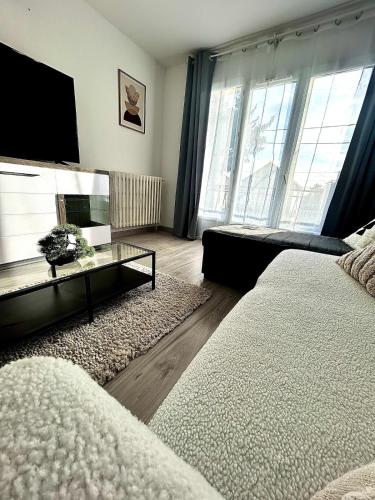 Maison cosy في غوسافييل: غرفة معيشة مع سرير وتلفزيون