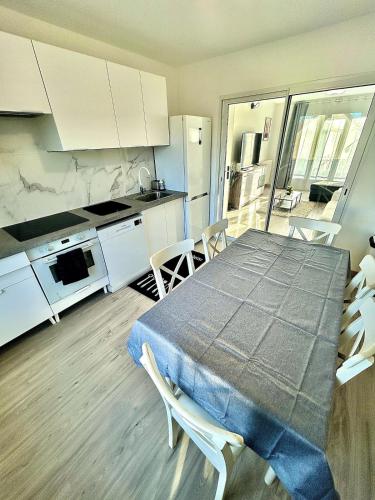 Maison cosy في غوسافييل: مطبخ به طاولة وكراسي في غرفة