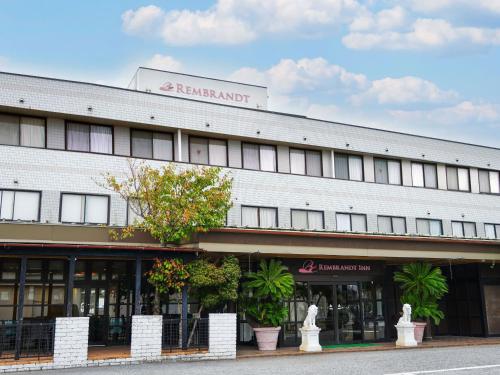 a white building with a sign on top of it at Rembrandt Inn Kazusa in Kimitsu