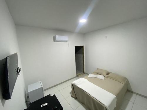 a room with a bed and a television in it at Sol Dos Lençois Pousada in Barreirinhas