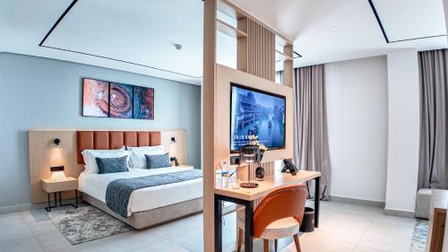 Una habitación de hotel con una cama y un escritorio y un escritorio. en MH HOTEL Nouakchott, en Nouakchott