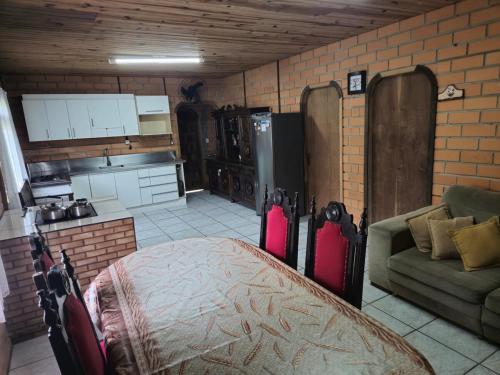 a living room with a couch and a kitchen at Sito São Joaquim in Itaquá