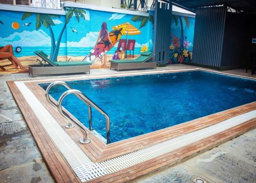 a large swimming pool with a mural on the side of a building at Mthree residence and apartment Ltd in Abuja