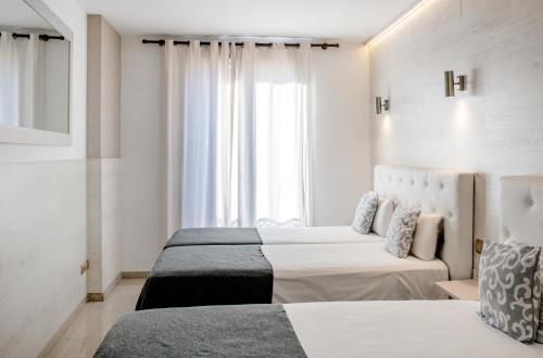 a bedroom with two beds and a window at Aparthotel Rambla108 in Barcelona