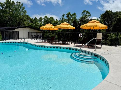 a large blue swimming pool with umbrellas on top at Arka Motel in Rogers