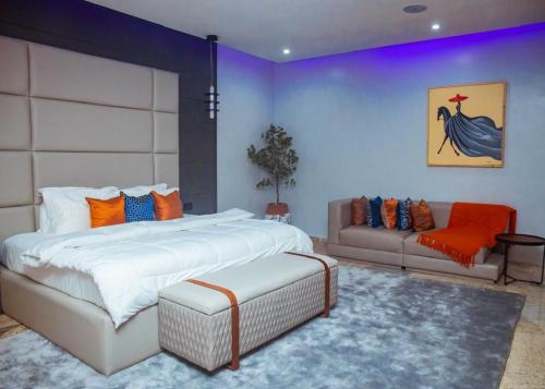 a bedroom with a large bed and a couch at Mthree residence and apartment Ltd in Abuja