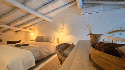 a bedroom with two beds and a table at Villa Oliva São Pedro in São Pedro do Corval