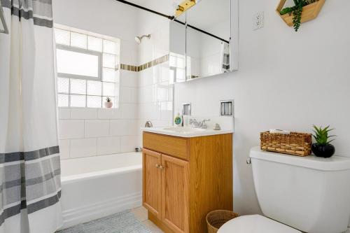 a bathroom with a toilet and a tub and a sink at Curated for Cozy Longer Stays in Westmont