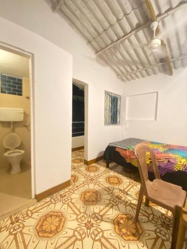 a bedroom with a bed and a chair in a room at Messianic guest house in Arambol