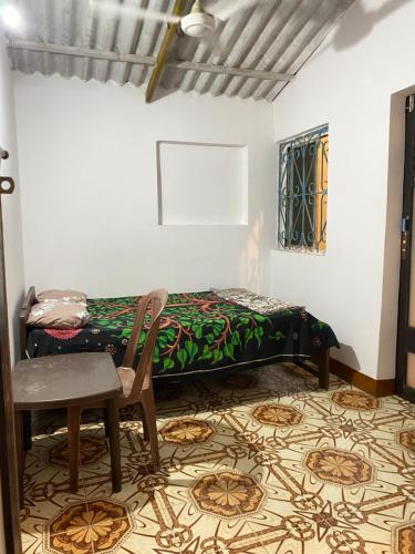 a bedroom with a bed and a chair and a table at Messianic guest house in Arambol
