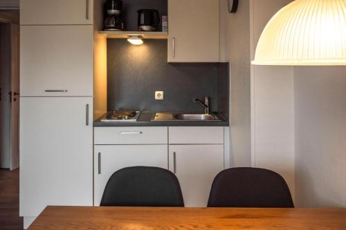 a kitchen with a table and two chairs and a sink at Deichkoje 1 Dagebüll in Dagebüll