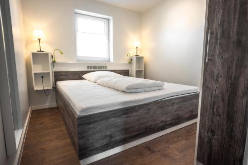 a bedroom with a large bed with a window at Deichkoje 1 Dagebüll in Dagebüll