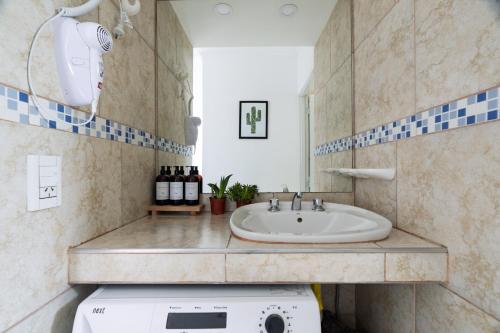 Un baño con lavabo y lavadora. en Hermosa Casa En El Centro de San Rafael, en San Rafael