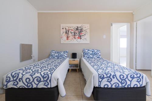 Un dormitorio con dos camas con sábanas azules y blancas. en Hermosa Casa En El Centro de San Rafael, en San Rafael