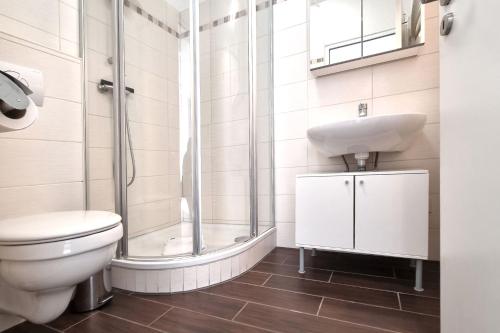 a bathroom with a toilet and a sink and a shower at Haus Spökenkieker in Borkum