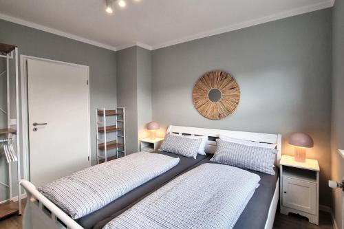 a bedroom with two beds and a mirror on the wall at Haus Spökenkieker in Borkum