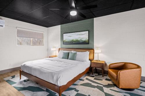 a bedroom with a bed and a chair at Arka Motel in Rogers