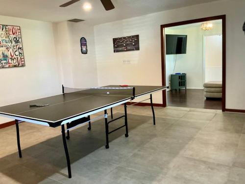 a ping pong table in the middle of a room at Spacious Arcade Table Tennis Game Room Cowboy Pool Near Tx Motor Speedwayby Vacation Your Way in Fort Worth
