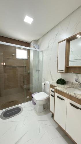un bagno con wc e doccia in vetro di Apto Flor Três Marias-2 Quartos- Apto todo climatizado- Moderno, confortável, à 150m do Parque Termal a Piratuba