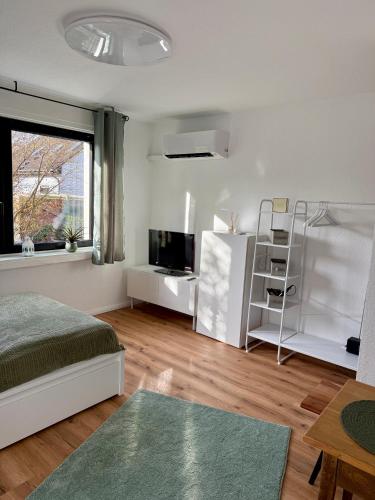 a bedroom with a bed and a tv and a window at Grüne Oase in Stadtnähe in Unna