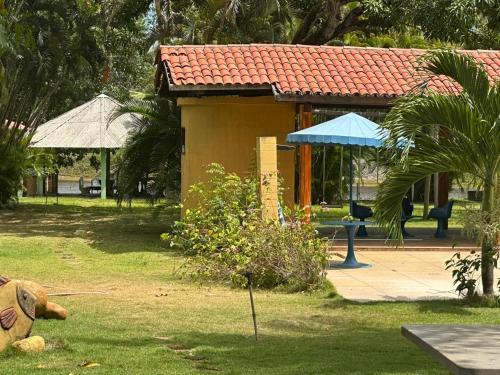 ein Gebäude in einem Park mit einem Baum und einem Haus in der Unterkunft Casa fazenda Paracuru in Paracuru