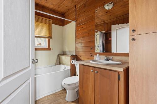 a bathroom with a toilet and a tub and a sink at The Tiny Cozy Retreat in Saint-Just-de-Bretenières
