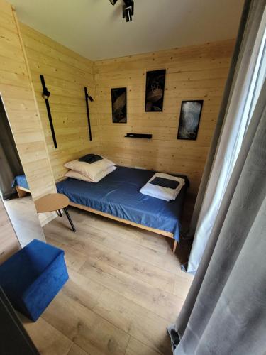 ZagłęboczeにあるDOMKI BEATUS HOME Zagłęboczeの木製の部屋にベッド1台が備わるベッドルーム1室があります。