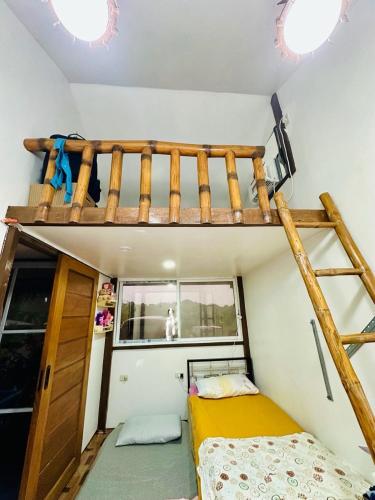 a small bedroom with a bunk bed and a ladder at TeamV Kubo Guesthouse in Agdañgan