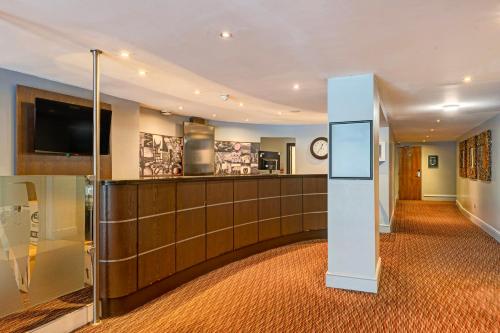 a lobby with a reception desk and a tv at Manchester Airport Stanley Hotel by Belvilla in Handforth