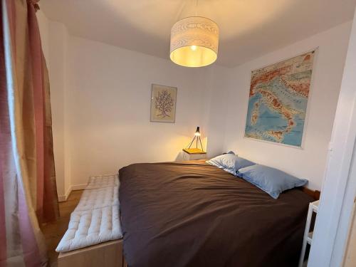 a bedroom with a large bed with a lamp on it at Treasure of Perche-Gouët in a village house! in Arrou