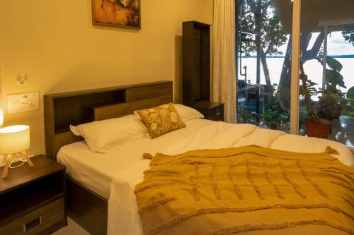 a bedroom with a large bed and a window at Lakefront 1 BR Cabin with Lake access & Hammock in Kollam