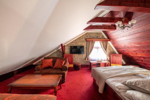 een zolderkamer met een bed en een bank bij Villa Rusalka in Vysoké Tatry