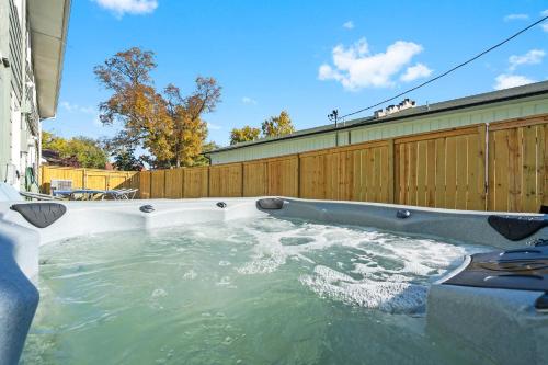 un jacuzzi dans une cour arrière avec une clôture en bois dans l'établissement Branson Downtown Beauty - 4 BDR Home Sleeps 15, à Branson