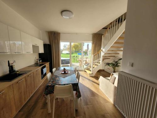 a kitchen and dining room with a table and a staircase at Agroturystyka Błądkowo 20A, Dom 11 miejsc in Błądkowo