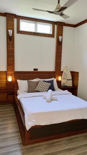 a bedroom with a large bed with a ceiling at Akiri Surf Retreat in Thulusdhoo