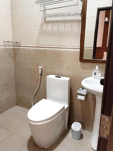 a bathroom with a white toilet and a sink at Akiri Surf Retreat in Thulusdhoo