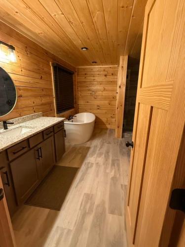 baño de madera con bañera y lavamanos en Savannah Smiles, en Williamsburg