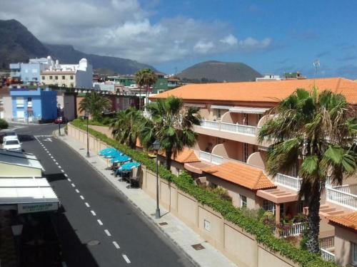 eine Straße in einer Stadt mit Palmen und Gebäuden in der Unterkunft Live La Caleta Mar de plata 14 in Caleta de Interián