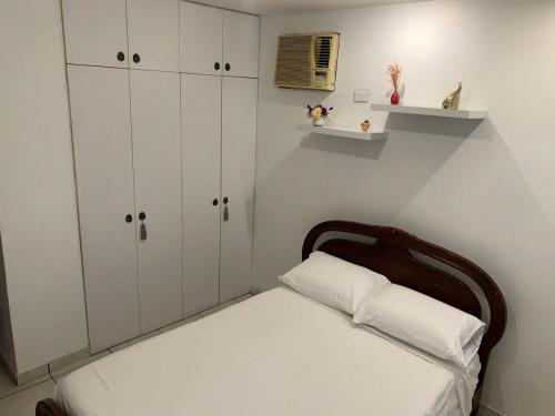 - une petite chambre avec un lit et des placards blancs dans l'établissement Fully furnished apartment Samborondón Guayaquil, à SamborondÃ³n